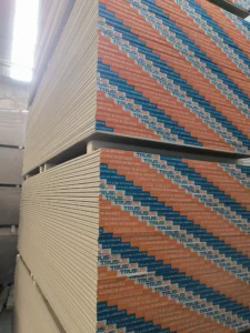 Close-up of large stacks of gypsum board with labeled packaging in a warehouse environment.