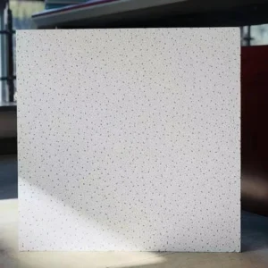A white slab with small speckles in a well-lit area, showcasing its texture and surface detail.