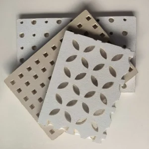 Three decorative perforated panels with geometric patterns, including circles, squares, and a leaf design, stacked on a white surface.